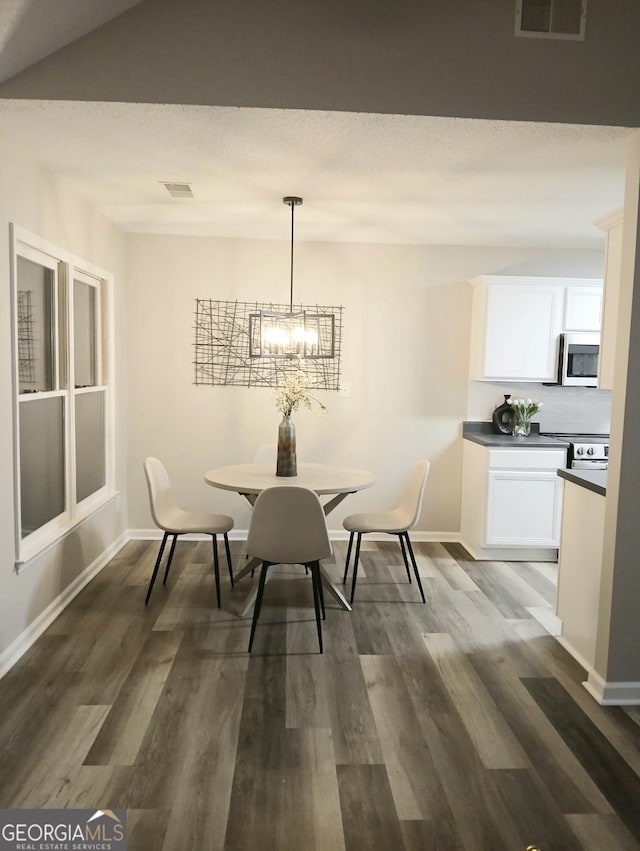 dining room with a notable chandelier and dark hardwood / wood-style floors