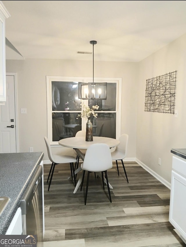 dining room featuring dark wood-type flooring and a notable chandelier