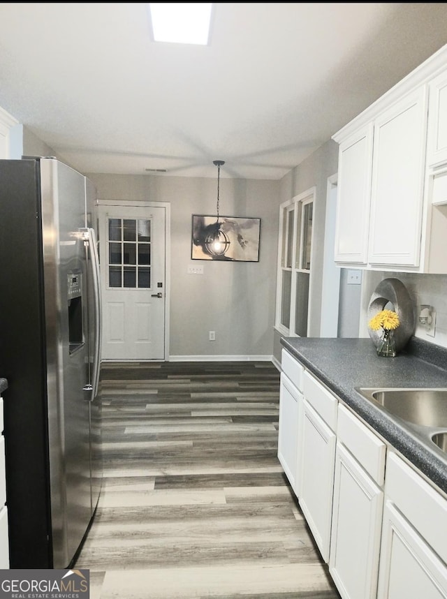 kitchen featuring decorative light fixtures, dark hardwood / wood-style floors, white cabinets, and stainless steel refrigerator with ice dispenser