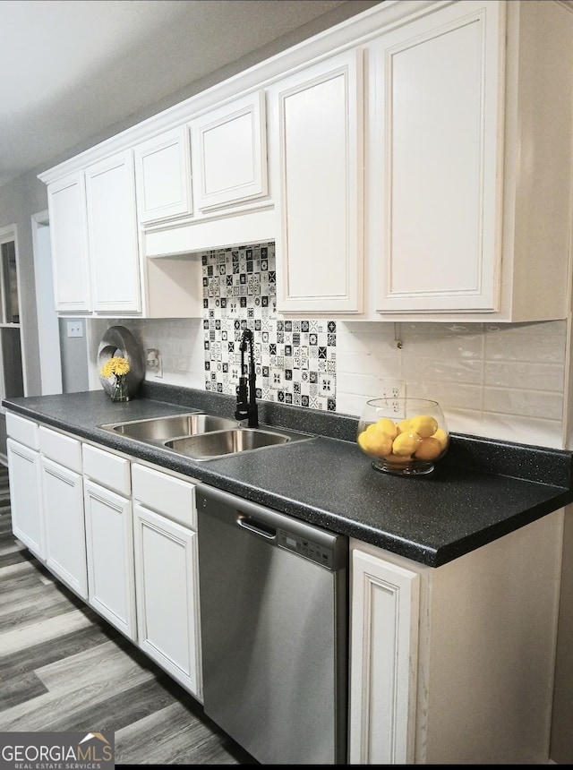 kitchen featuring sink, hardwood / wood-style floors, white cabinets, decorative backsplash, and stainless steel dishwasher