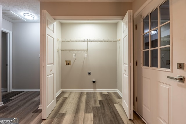 clothes washing area featuring electric dryer hookup, washer hookup, hardwood / wood-style flooring, and a textured ceiling