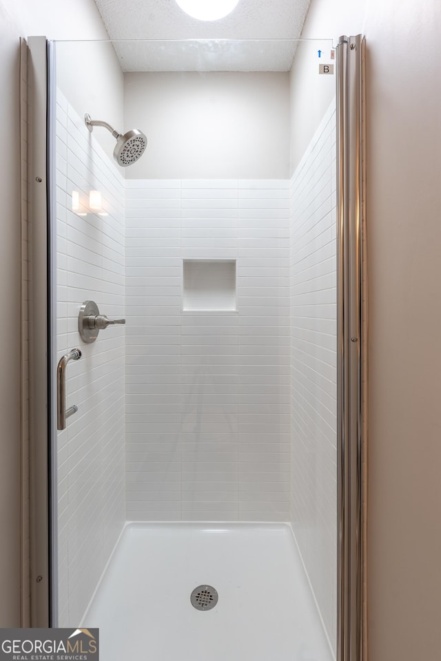 bathroom featuring a shower with shower door