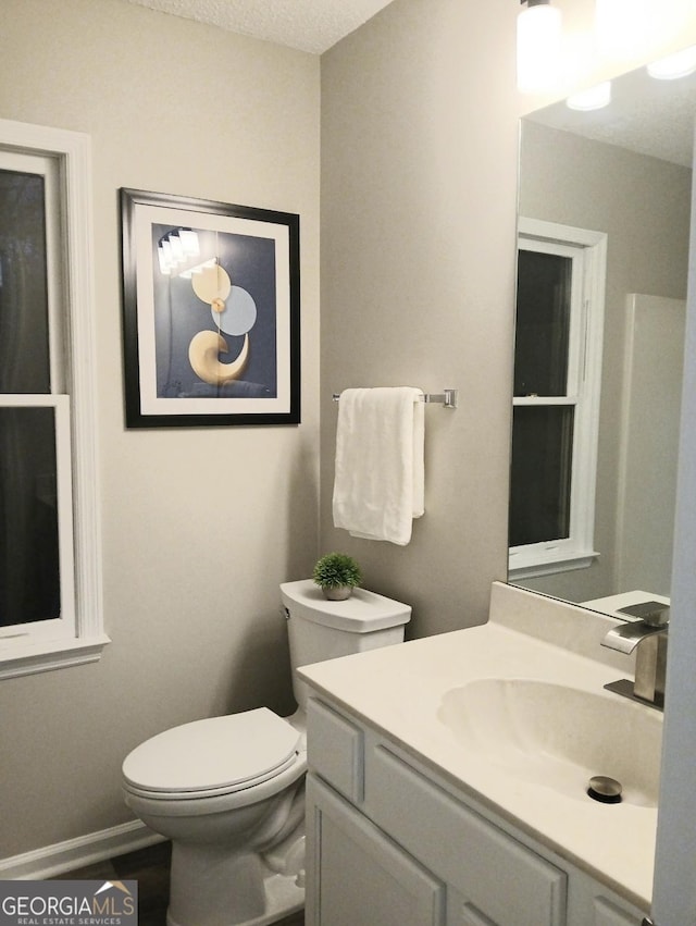 bathroom featuring vanity, toilet, and a textured ceiling