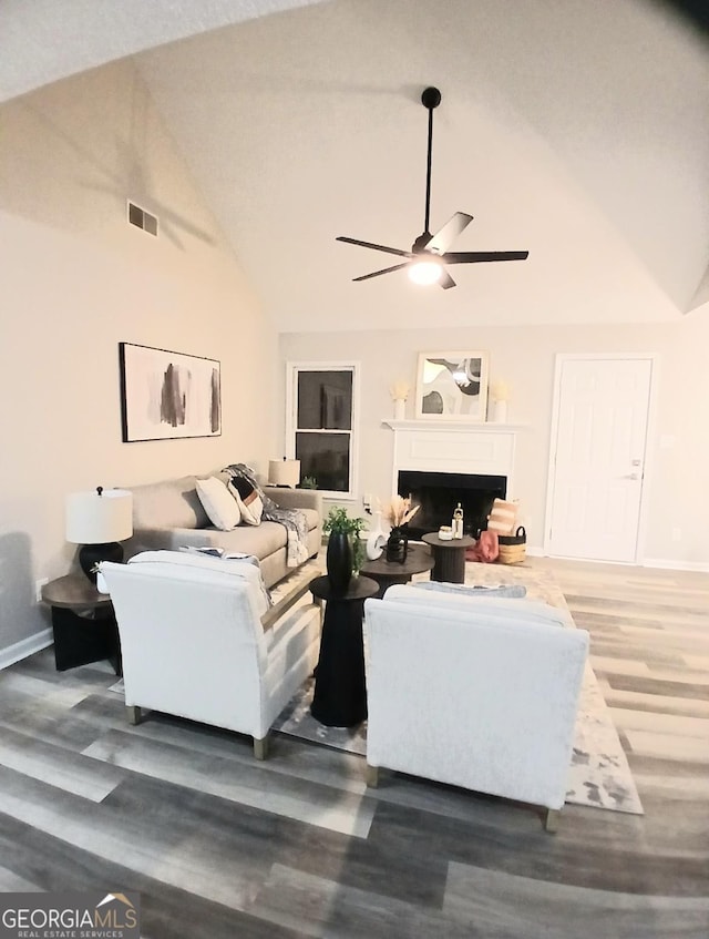 living room featuring ceiling fan, hardwood / wood-style floors, and high vaulted ceiling