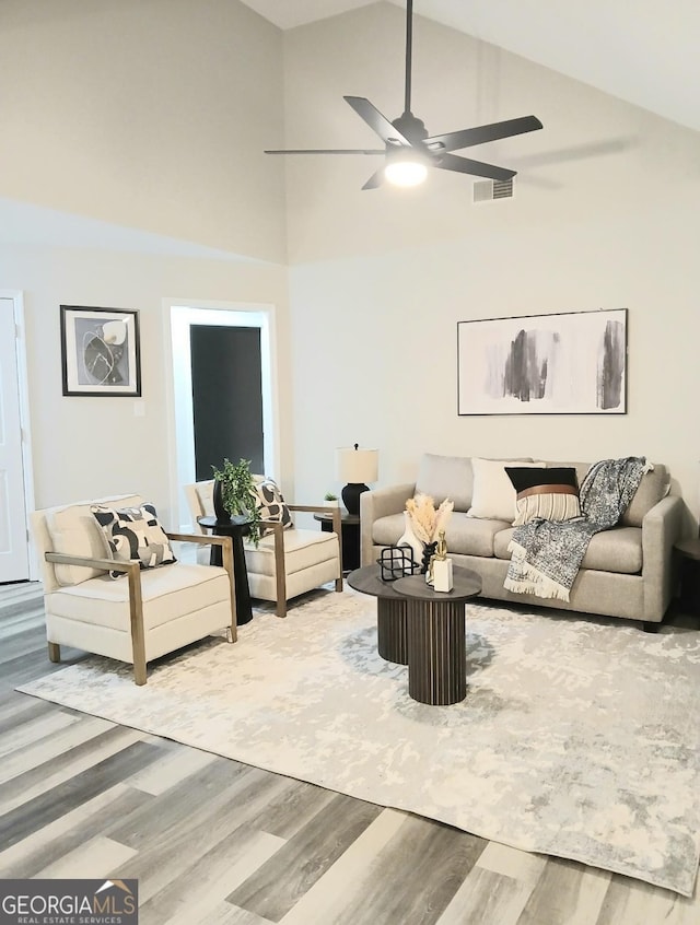 living room with hardwood / wood-style flooring, high vaulted ceiling, and ceiling fan