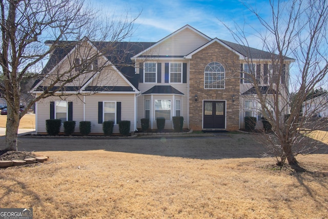 view of front of property featuring a front yard and french doors