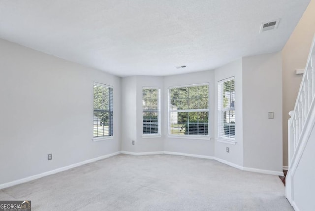 unfurnished room featuring light carpet