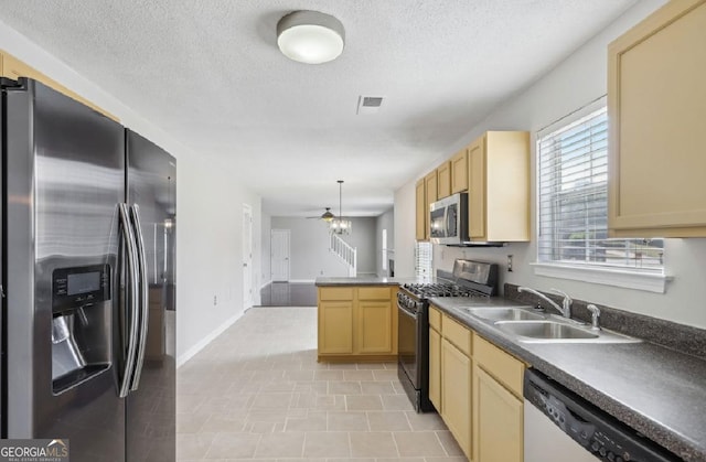 kitchen with light brown cabinetry, sink, hanging light fixtures, kitchen peninsula, and stainless steel appliances