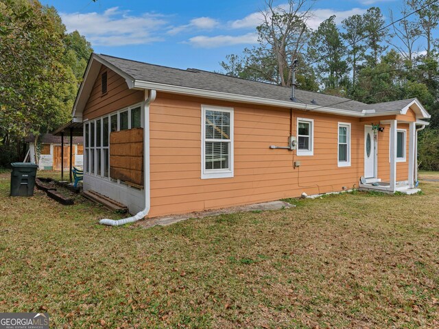 view of home's exterior with a yard and a sunroom