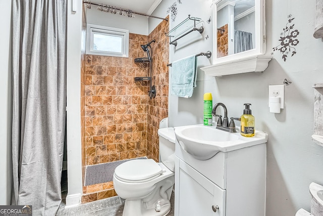 full bathroom with a tile shower, vanity, and toilet