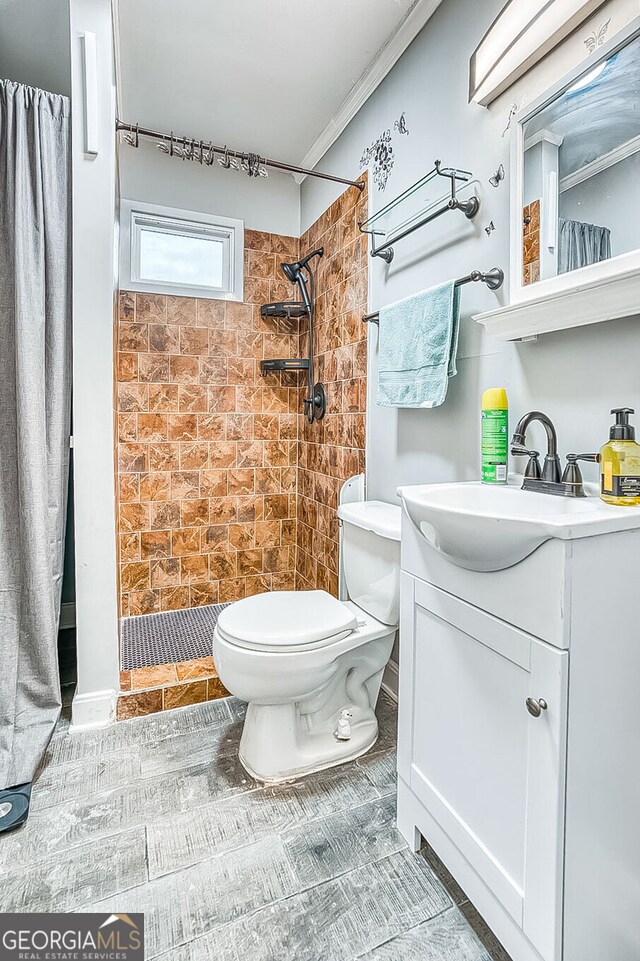 bathroom with a shower with curtain, vanity, ornamental molding, and toilet