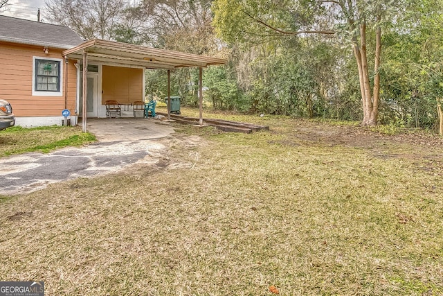 view of yard featuring a carport and driveway