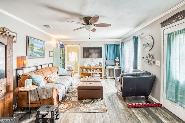 living room with crown molding, ceiling fan, and wood-type flooring