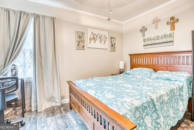 bedroom with hardwood / wood-style flooring and ornamental molding