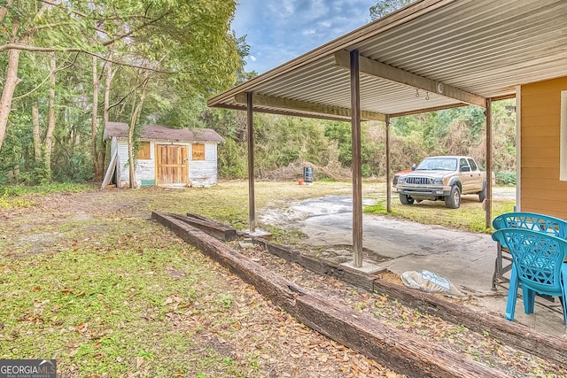 view of yard with a storage shed, a patio, and an outbuilding