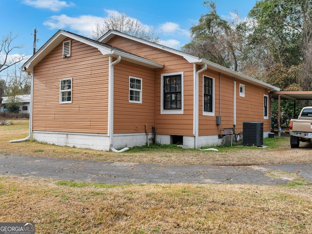 view of side of home with cooling unit and a carport