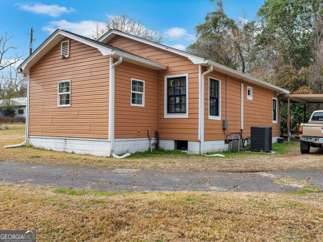 view of property exterior featuring a carport and central air condition unit