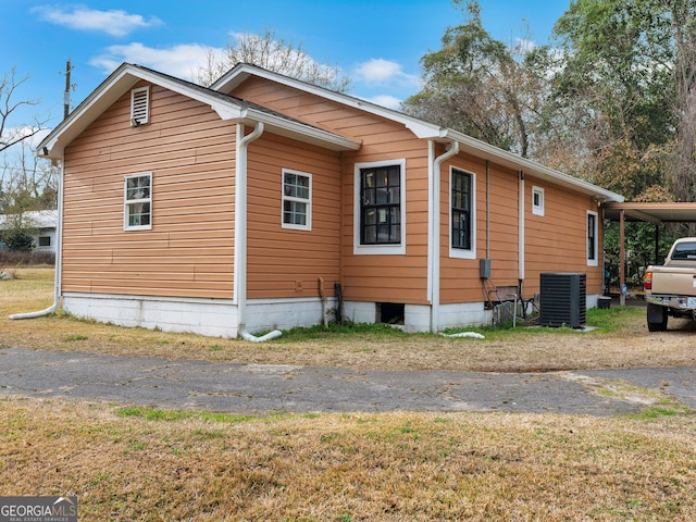 view of side of home with central air condition unit and a carport