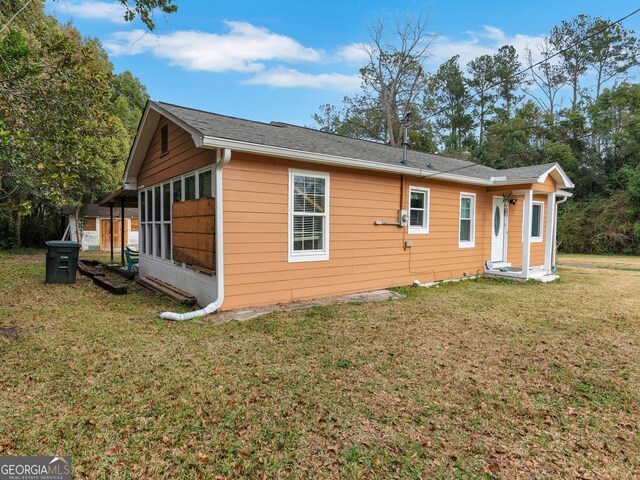 rear view of property featuring a lawn