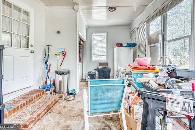 interior space featuring ornamental molding and unfinished concrete flooring