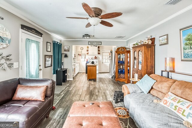 living room with ceiling fan, ornamental molding, and dark hardwood / wood-style flooring