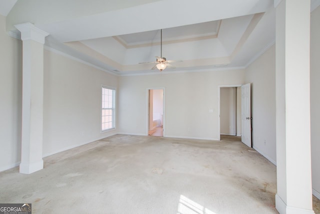 empty room featuring light carpet, crown molding, decorative columns, a raised ceiling, and ceiling fan