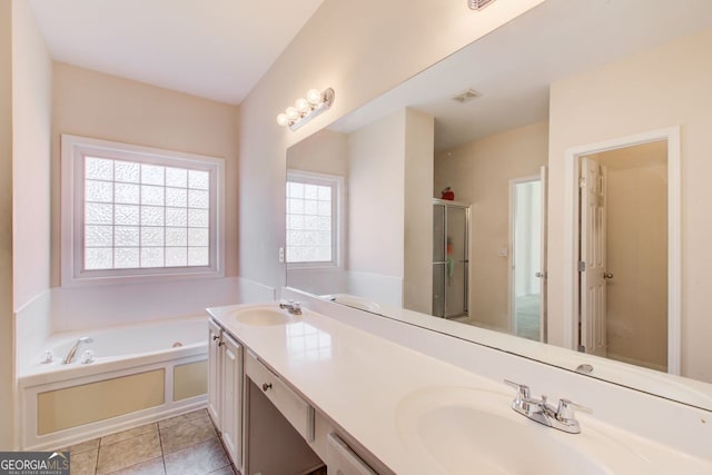 bathroom featuring a sink, a garden tub, and tile patterned flooring