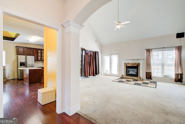 unfurnished living room featuring a wealth of natural light, ceiling fan, high vaulted ceiling, and ornate columns