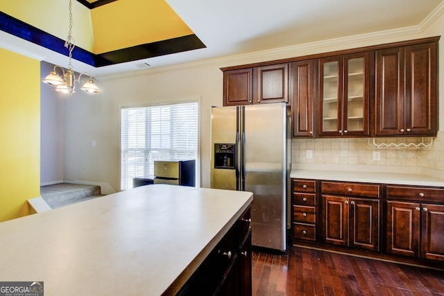 kitchen featuring glass insert cabinets, dark wood finished floors, decorative light fixtures, light countertops, and stainless steel refrigerator with ice dispenser