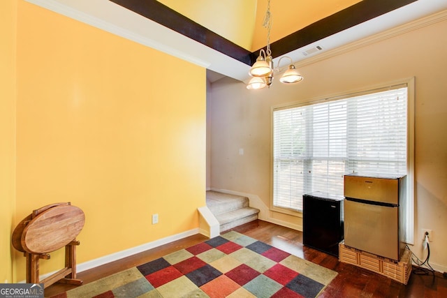 unfurnished office featuring visible vents, dark wood-type flooring, ornamental molding, baseboards, and a chandelier