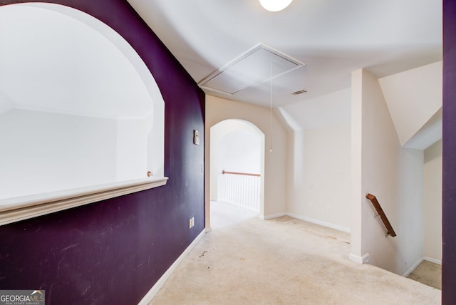 corridor featuring carpet, visible vents, attic access, vaulted ceiling, and an upstairs landing