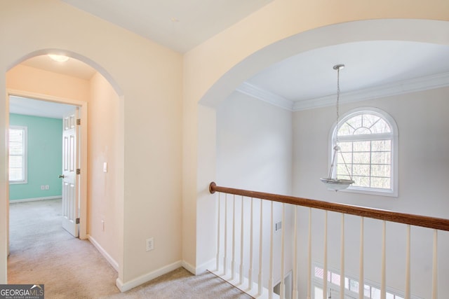 hallway featuring baseboards, a healthy amount of sunlight, and carpet flooring