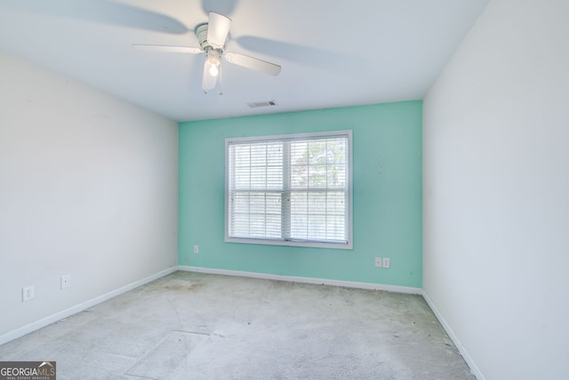 carpeted empty room featuring visible vents, baseboards, and a ceiling fan