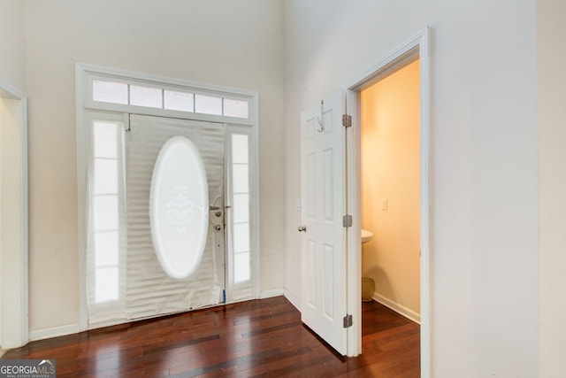 foyer with baseboards and hardwood / wood-style floors