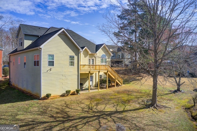 rear view of property featuring a patio, stairway, a yard, and a wooden deck