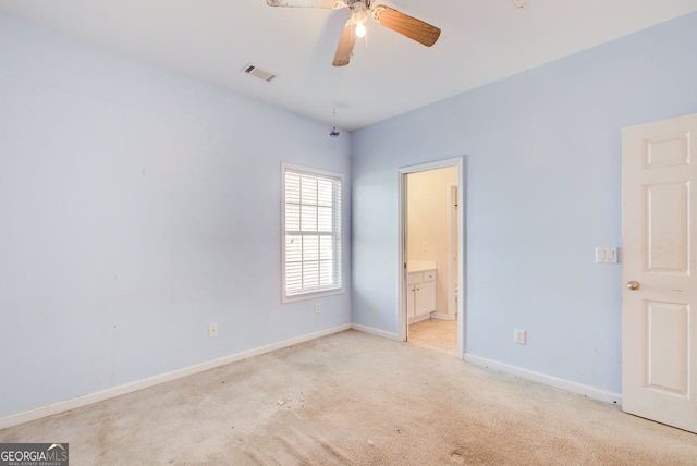 unfurnished bedroom with baseboards, visible vents, ensuite bathroom, and light carpet