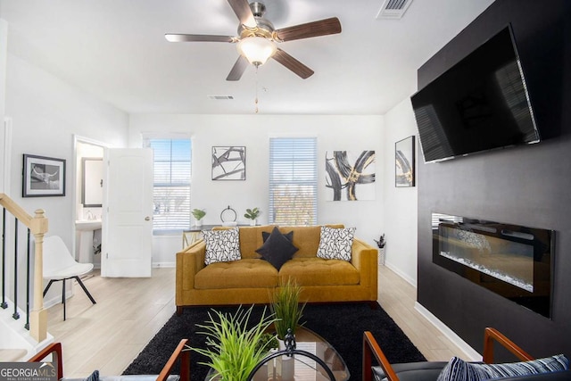 living room with ceiling fan and light wood-type flooring