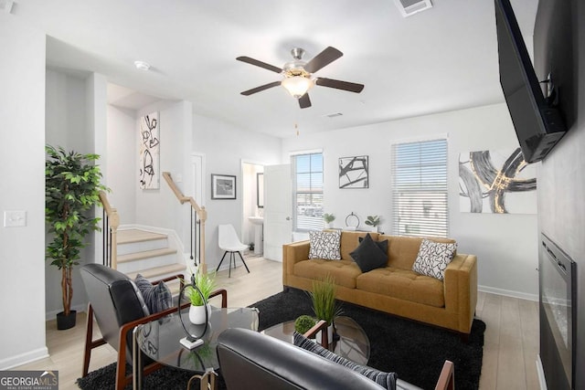 living room featuring ceiling fan and light hardwood / wood-style flooring