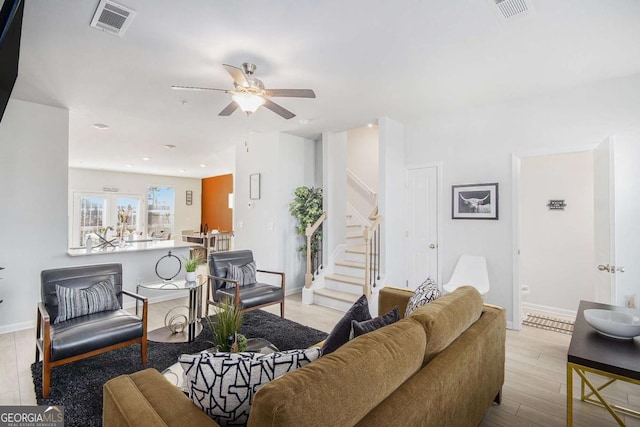 living room with ceiling fan and light hardwood / wood-style flooring