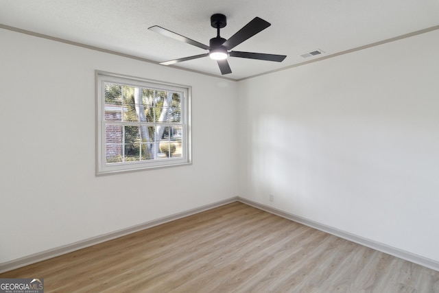 empty room with ceiling fan, crown molding, light hardwood / wood-style flooring, and a textured ceiling