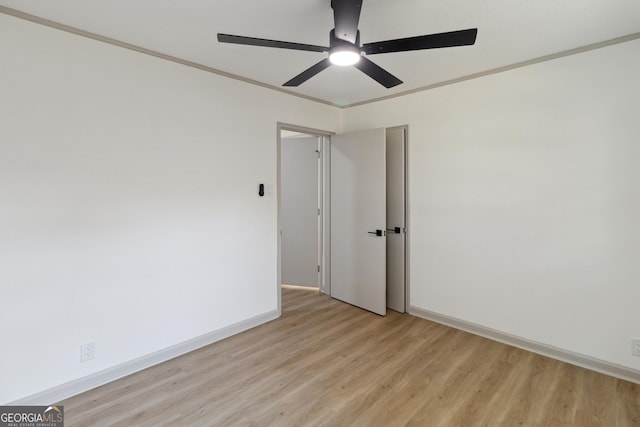 spare room with crown molding and light hardwood / wood-style flooring