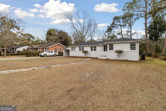 ranch-style home with cooling unit and a front yard