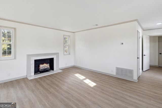 unfurnished living room featuring crown molding and light hardwood / wood-style flooring