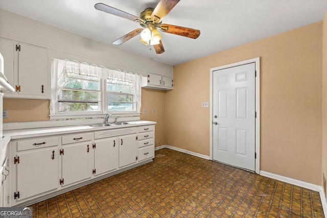 kitchen featuring white cabinetry, sink, and ceiling fan