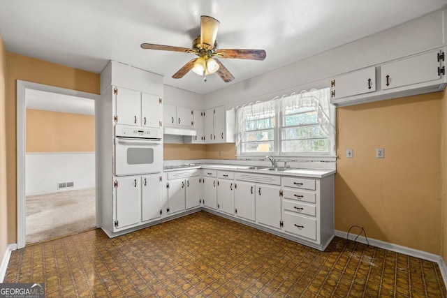 kitchen with sink, black electric cooktop, ceiling fan, white oven, and white cabinets