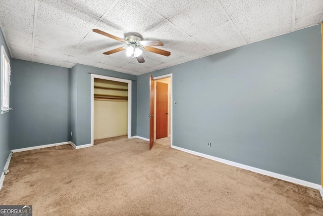 unfurnished bedroom featuring light colored carpet, a closet, and ceiling fan