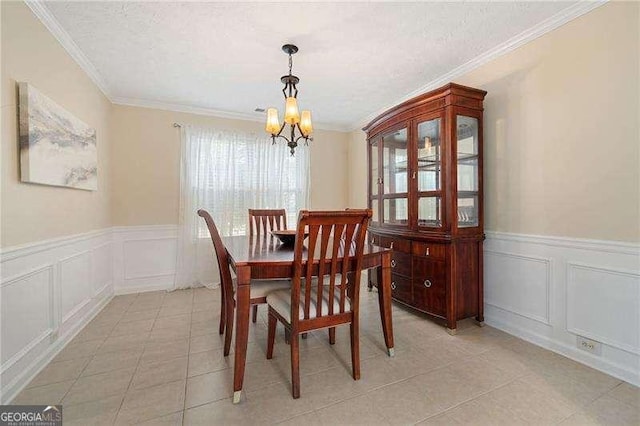 tiled dining space with ornamental molding, a textured ceiling, and an inviting chandelier