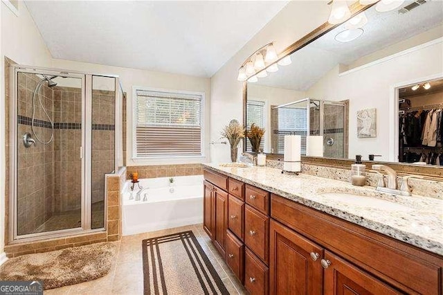 bathroom with vanity, tile patterned flooring, and plus walk in shower