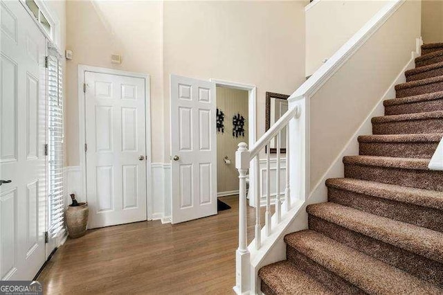 stairway featuring hardwood / wood-style floors and a high ceiling