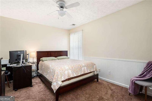 bedroom featuring ceiling fan, carpet floors, and a textured ceiling